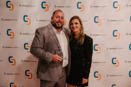 APEX team members Accepting award in front of step and repeat