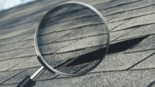 magnifying glass looking at shingles on roof